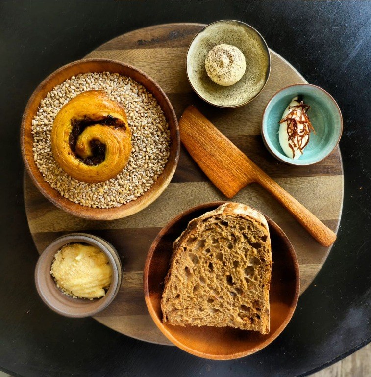 Sourdough, morning bun and cultured butter on a wooden board