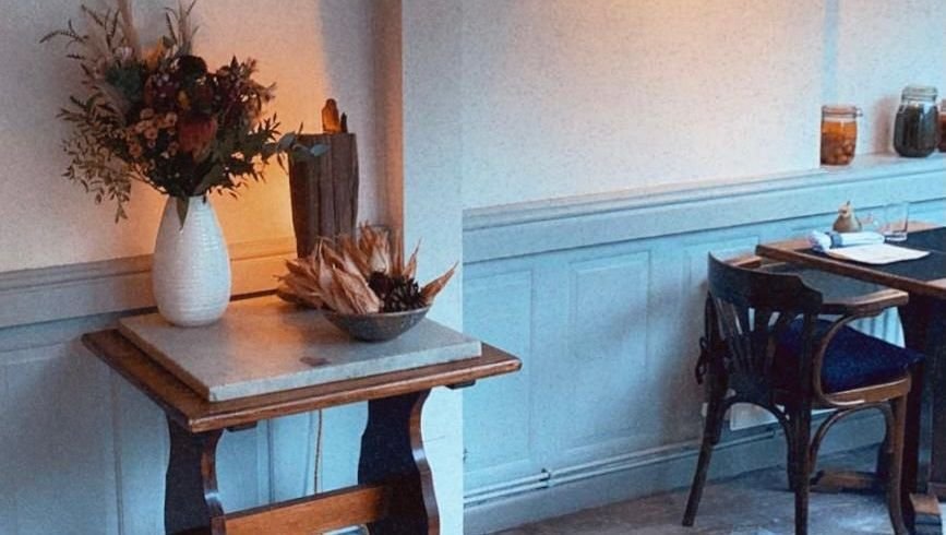 The Bulrush dining room: duck-egg blue panelling, marble console, dried arrangements